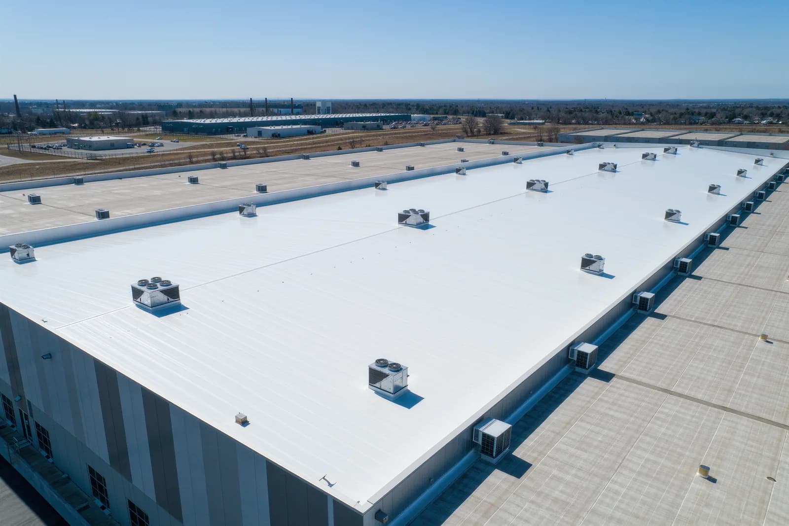 Aerial view of a large commercial building with a new white TPO membrane flat roof in Maryland