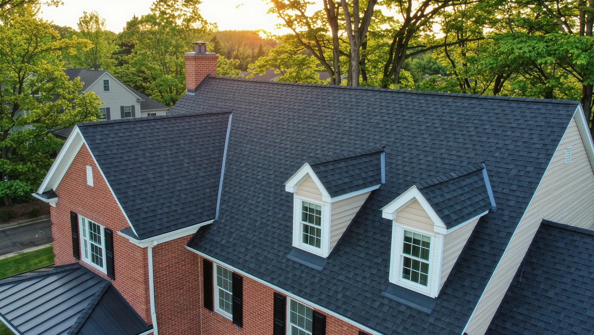 Aerial drone view of a newly installed charcoal architectural shingle roof on a brick colonial home in Frederick, Maryland
